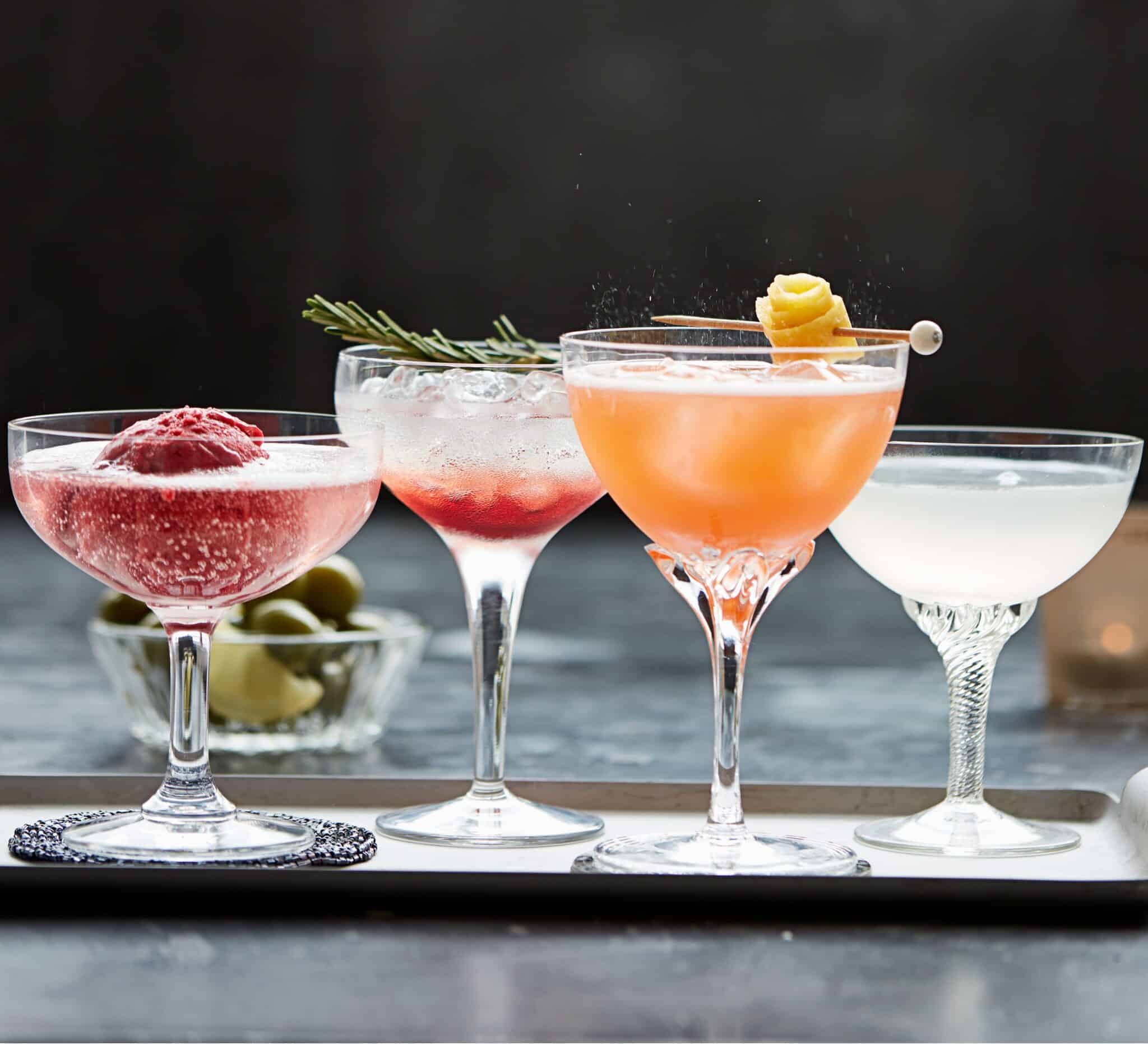4 different cocktails in different shape glasses with garnishes
