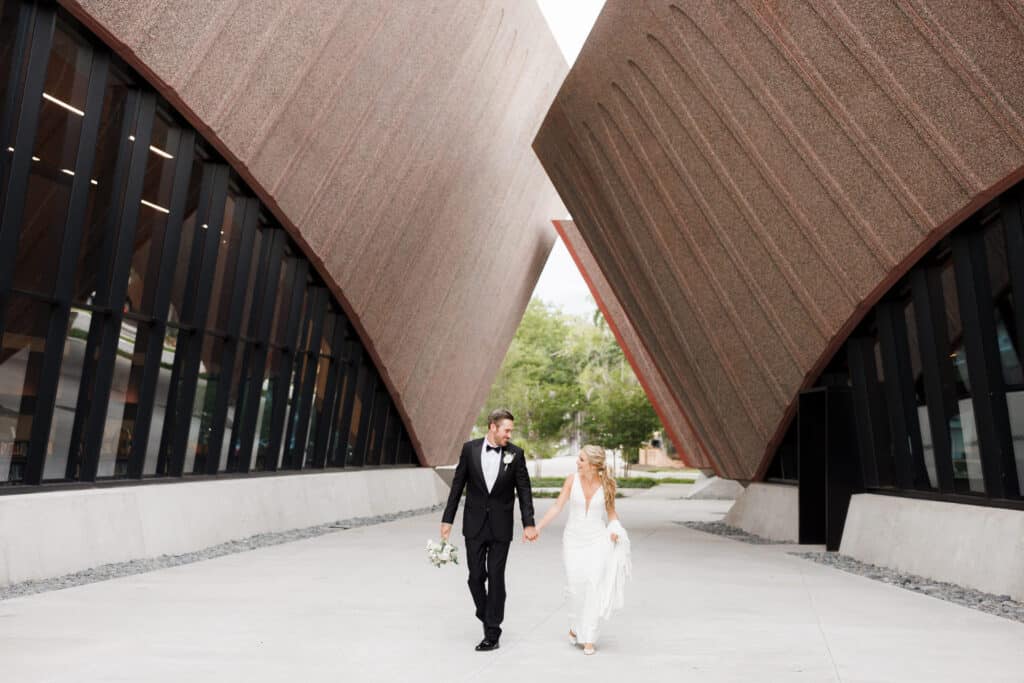 bride and groom walking through contemporary buildings photo by Allie & Joey