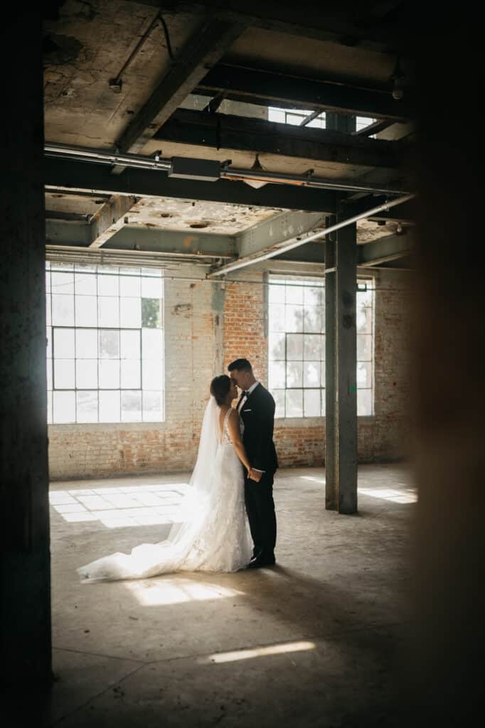 bride and groom in industrial building having a quiet dance photo by Allie & Joey