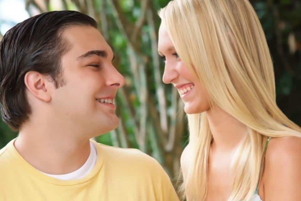 young couple up close smiling at each other