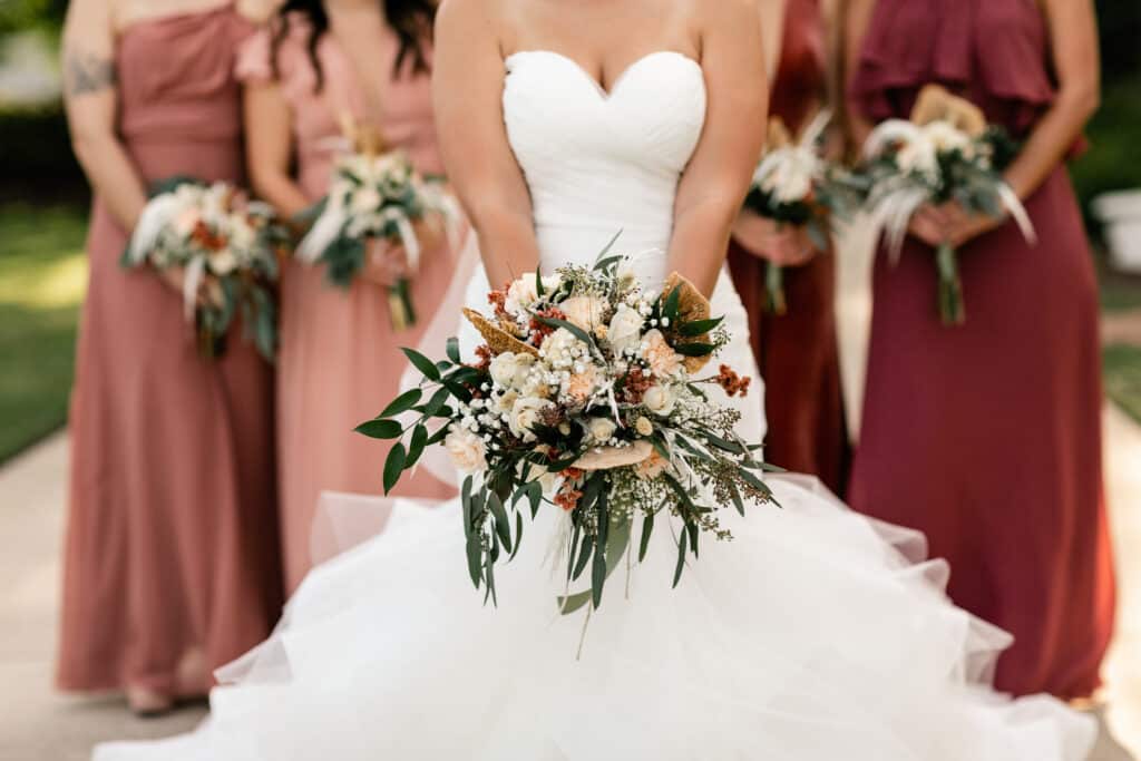 Torso view of bride and bridesmaids showing of bouquets