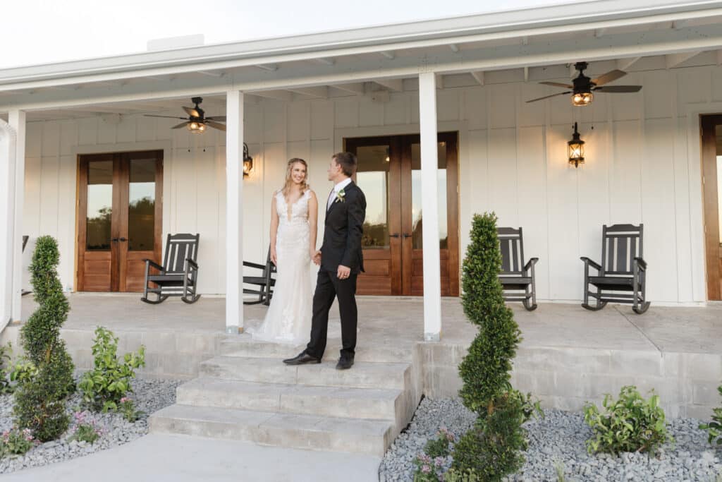 bride and groom on stairs of covered verandah at The Carriage House at Vedder Farms