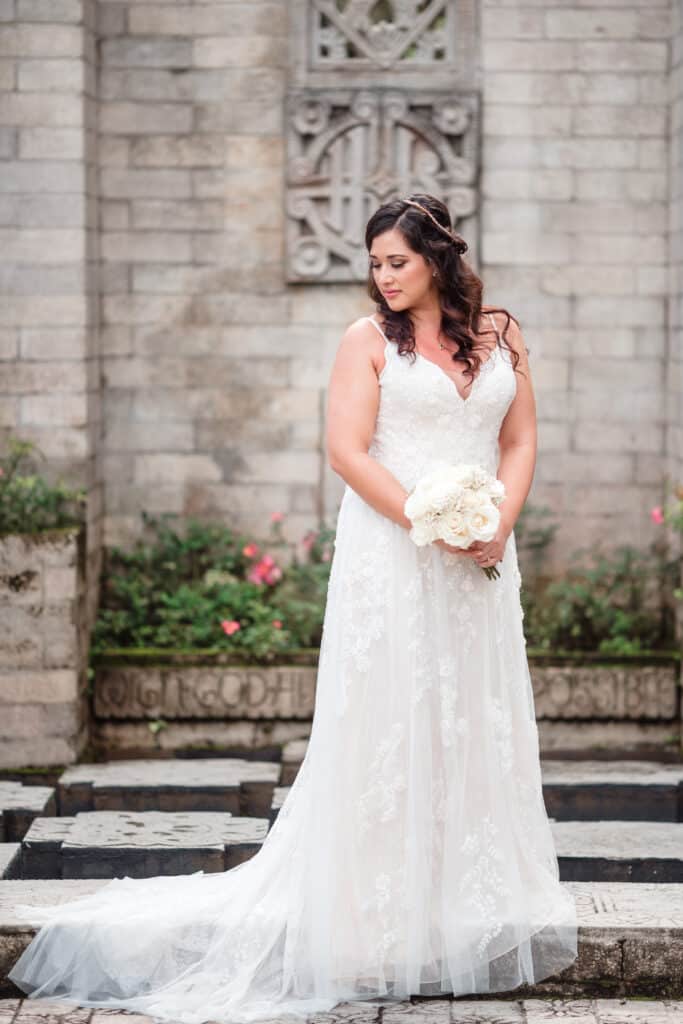 bride standing near a stone wall looking away photo by Jerzy Nieves Photography LLC