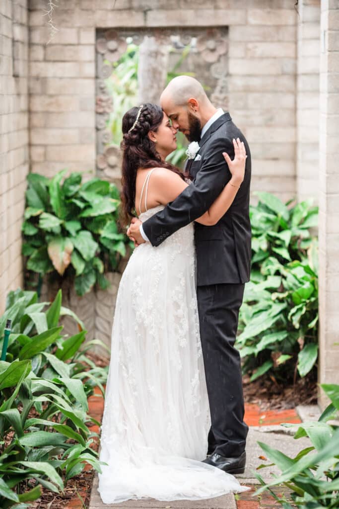 bride and groom share special moment in outdoor alcove with greenery all around photo by Jerzy Nieves Photography LLC