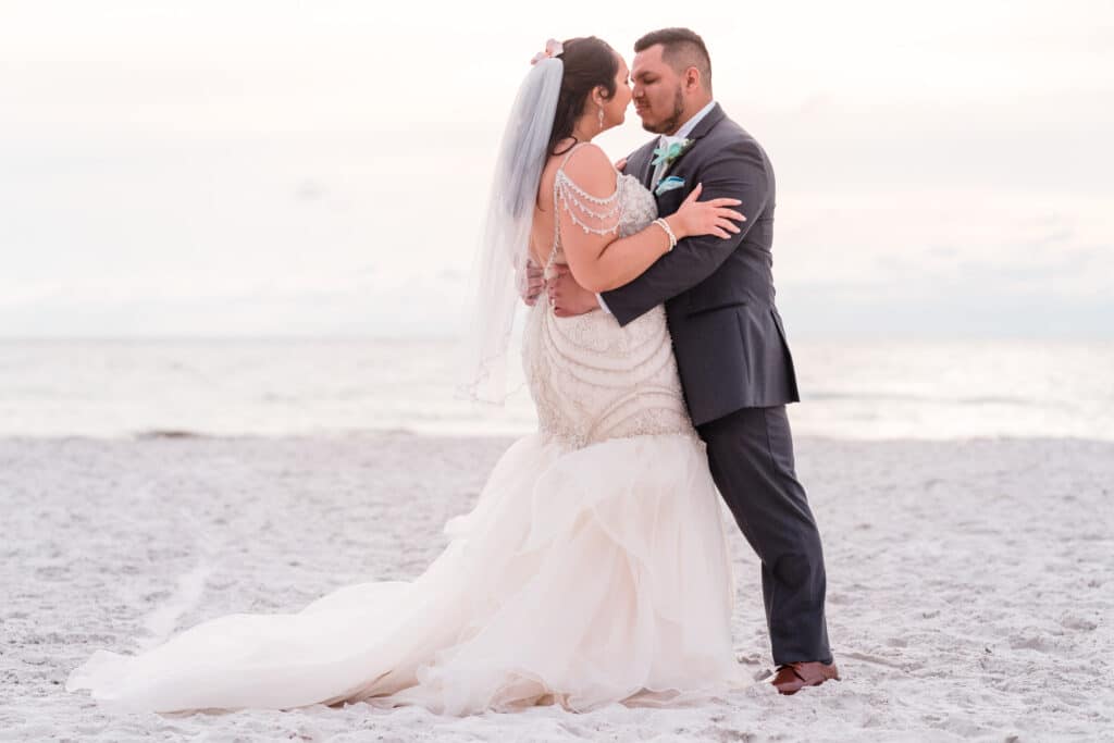 bride and groom posing on a beach photo by Jerzy Nieves Photography LLC