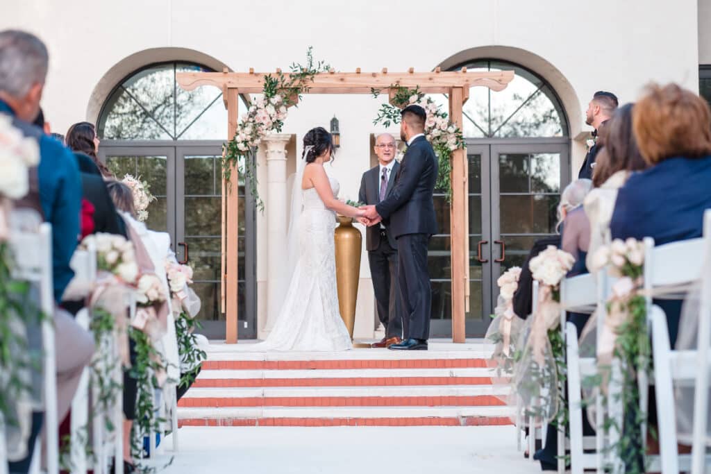 bride and groom at outdoor altar holding hands photo by Jerzy Nieves Photography LLC