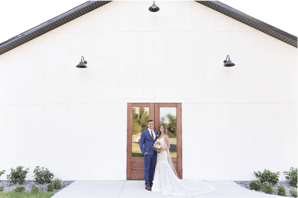 bride and groom stand in front of wooden doors at The Carriage House at Vedder Farms