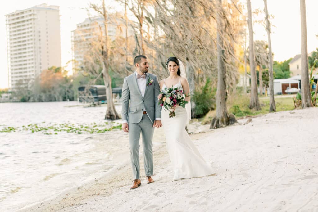 bride and groom walking on a sandy beach