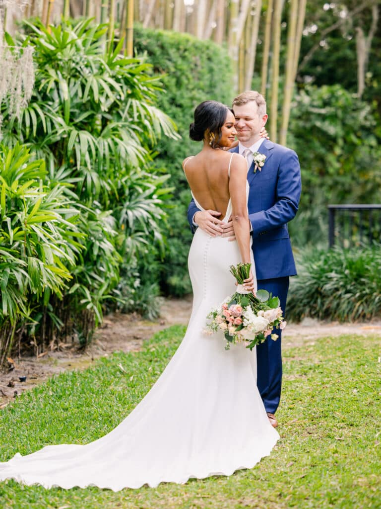 groom in a blue suit with bride in a private garden