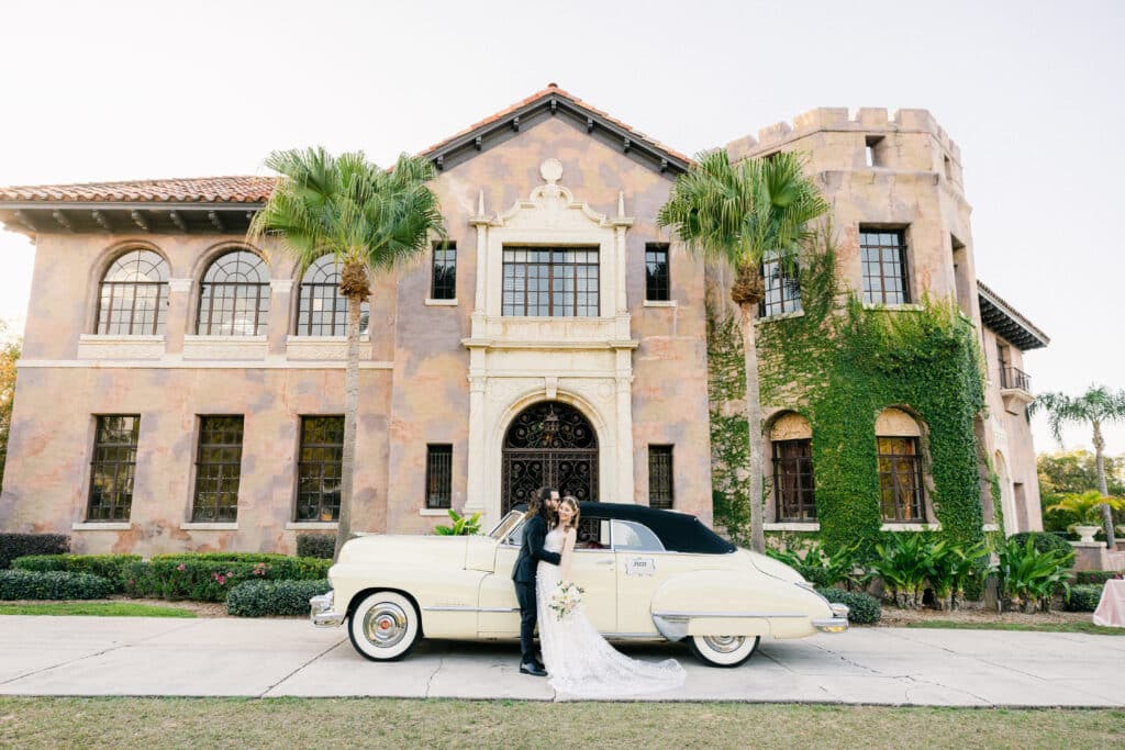 bride and groom making their getaway in front of a church with a vintage car