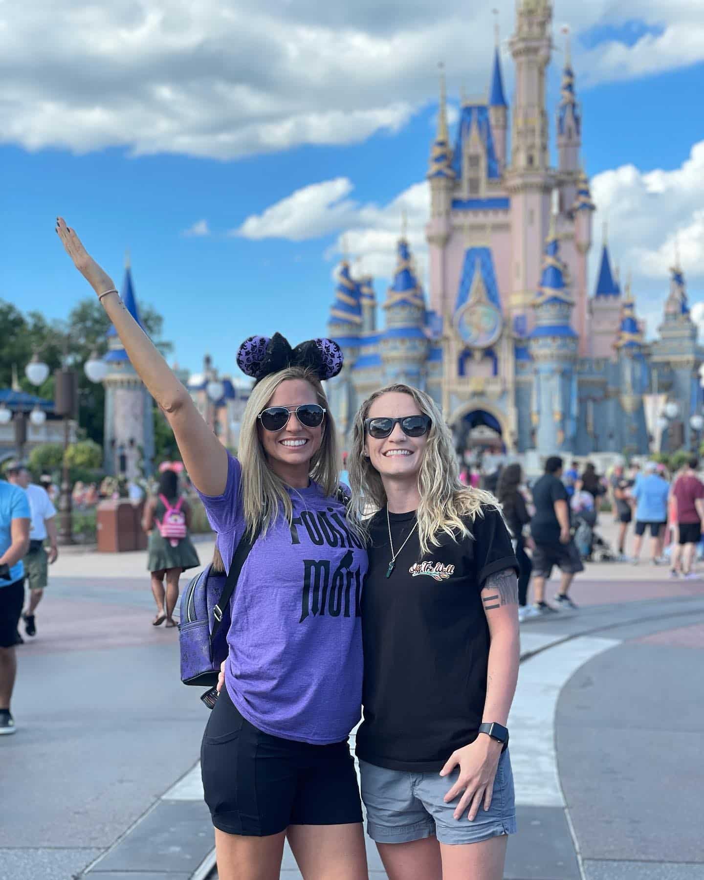couple poses together in front of castle at magic kingdom disney world