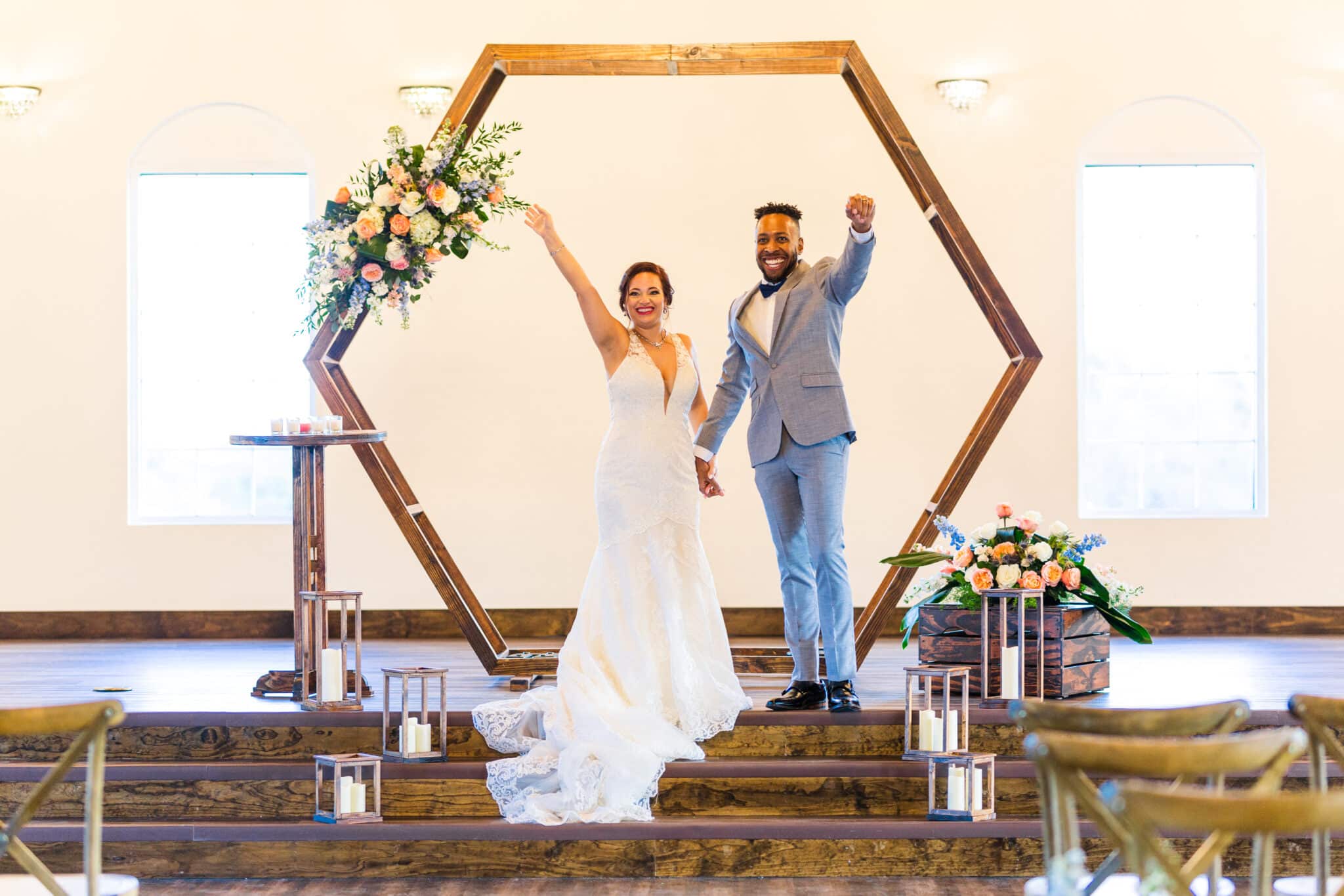 bride and groom standing at altar with hexagon ceremony arch behind them
