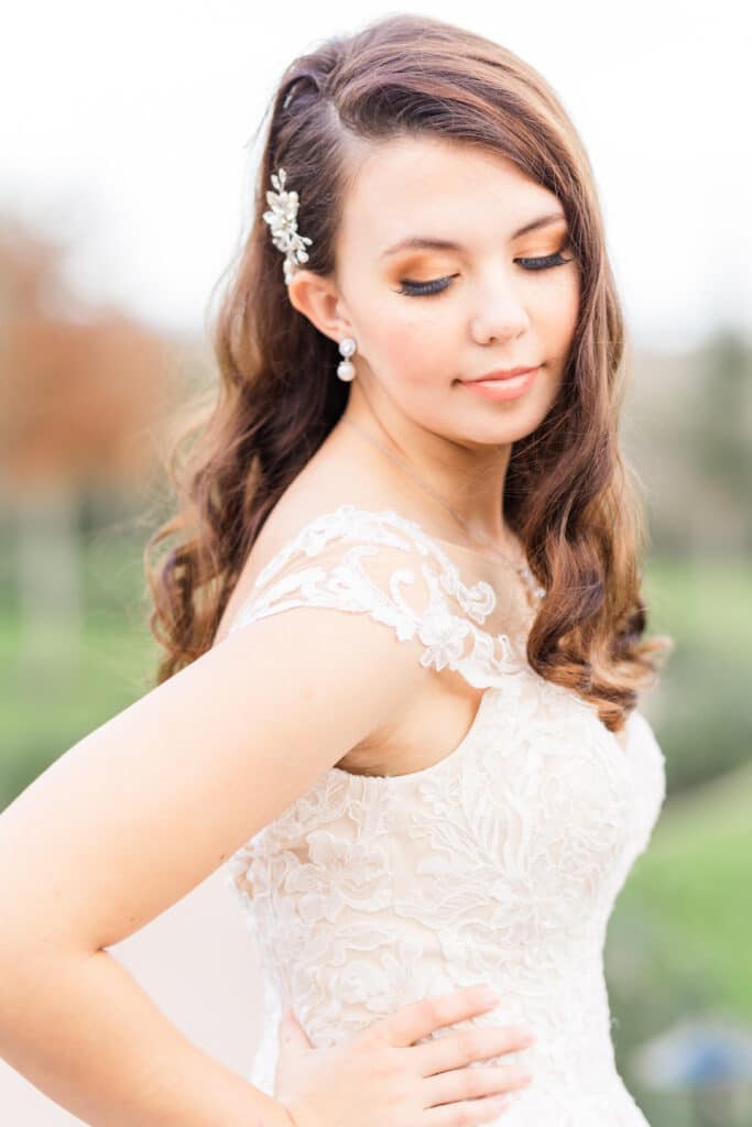 Close up of a bride with her hands on her hips looking down