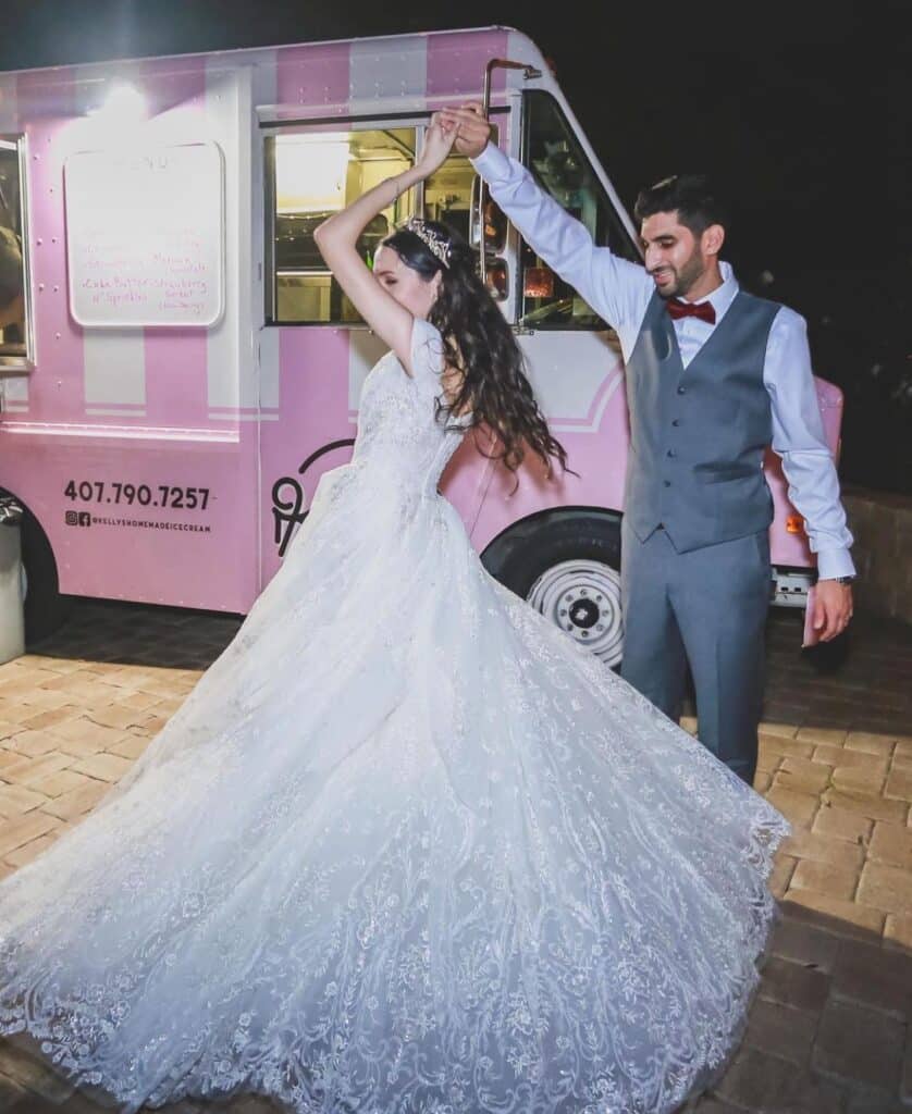 groom twirling bride in front of Kelly’s Homemade Ice Cream truck