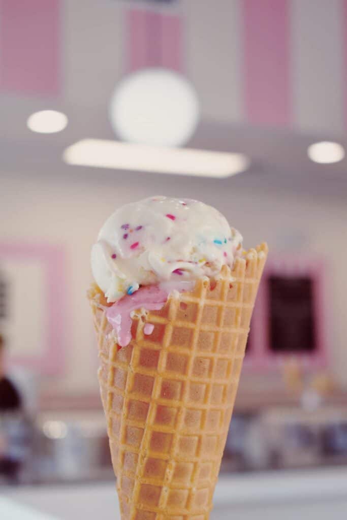 waffle cone with bubble gum ice cream scoop and vanilla ice cream with sprinkles from Kelly’s Homemade Ice Cream
