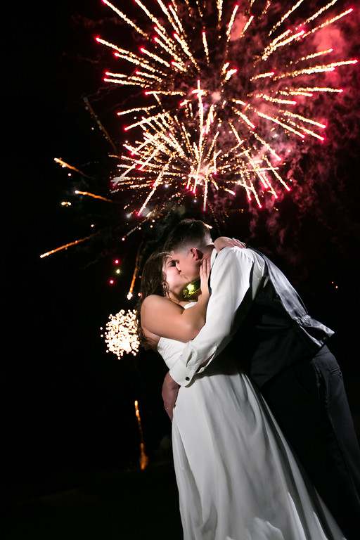 bride and groom kissing against a night sky lit with fireworks from Orlando Special Effects