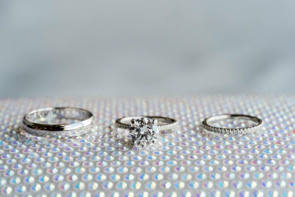 close-up photo of white gold titanium wedding rings and engagement ring