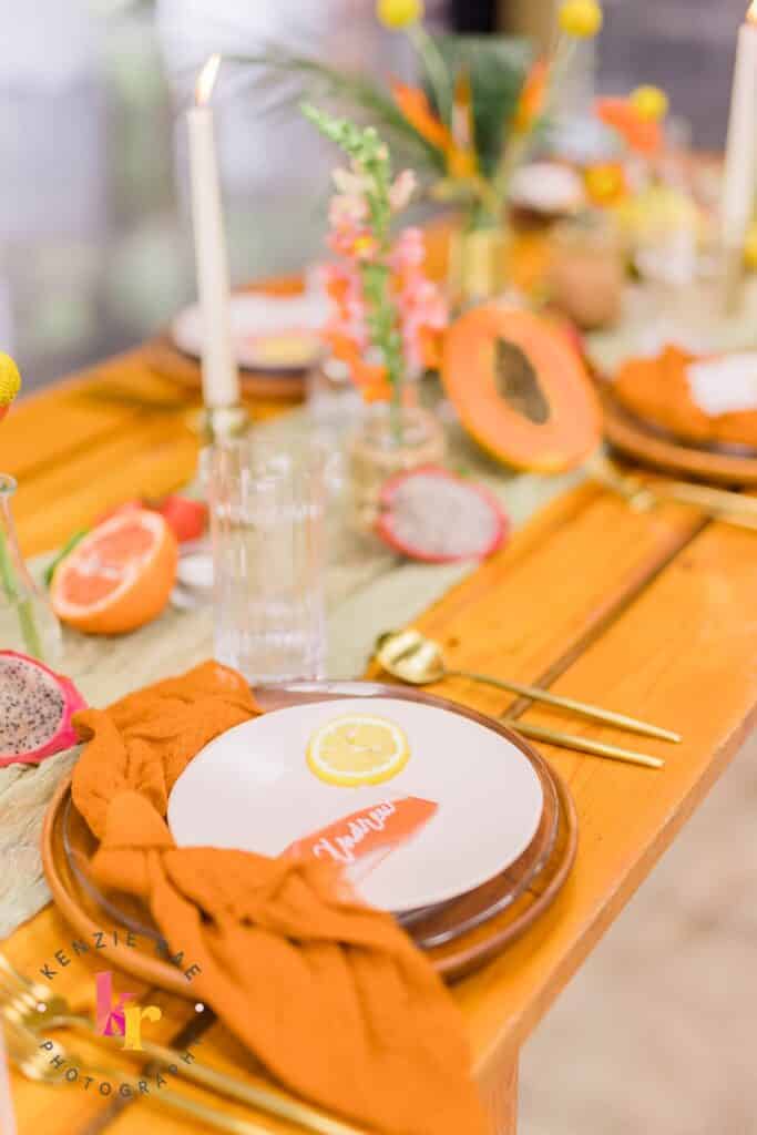 wedding reception tablescape in oranges and gold cutlery by Sweet Pea Design Collective