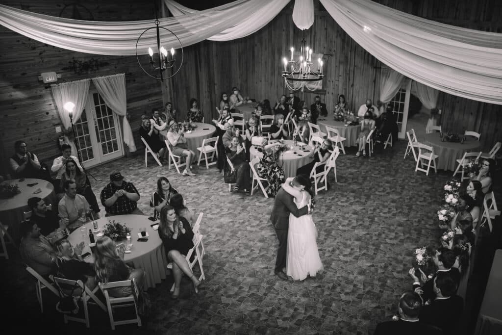 black and white photo of bride and groom's first dance in reception barn at the Diamond L Venue in Volusia County, near Deltona, FL