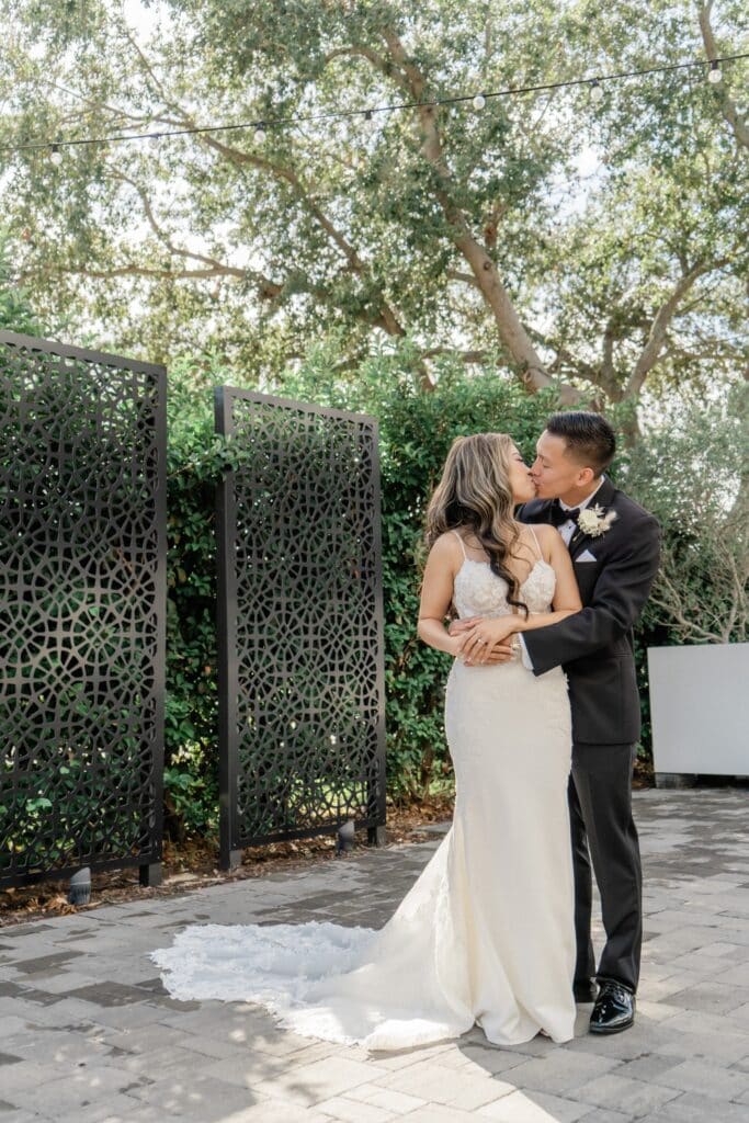 bride and groom kissing on outdoor patio