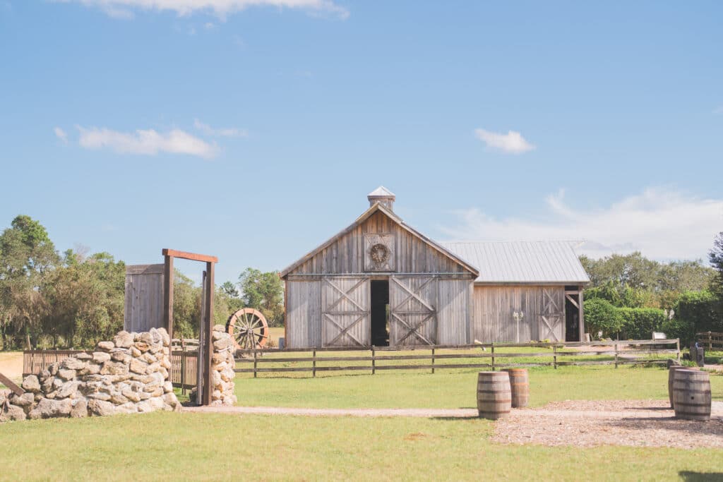 barn with rock wall and barrel lined drive at Bending Branch Ranch in New Smyrna Beach, FL