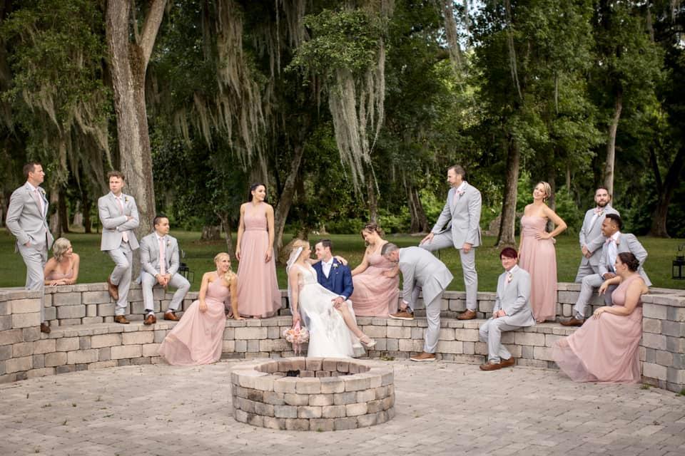 bridal party sitting around an outdoor firepit at October Oaks Farm