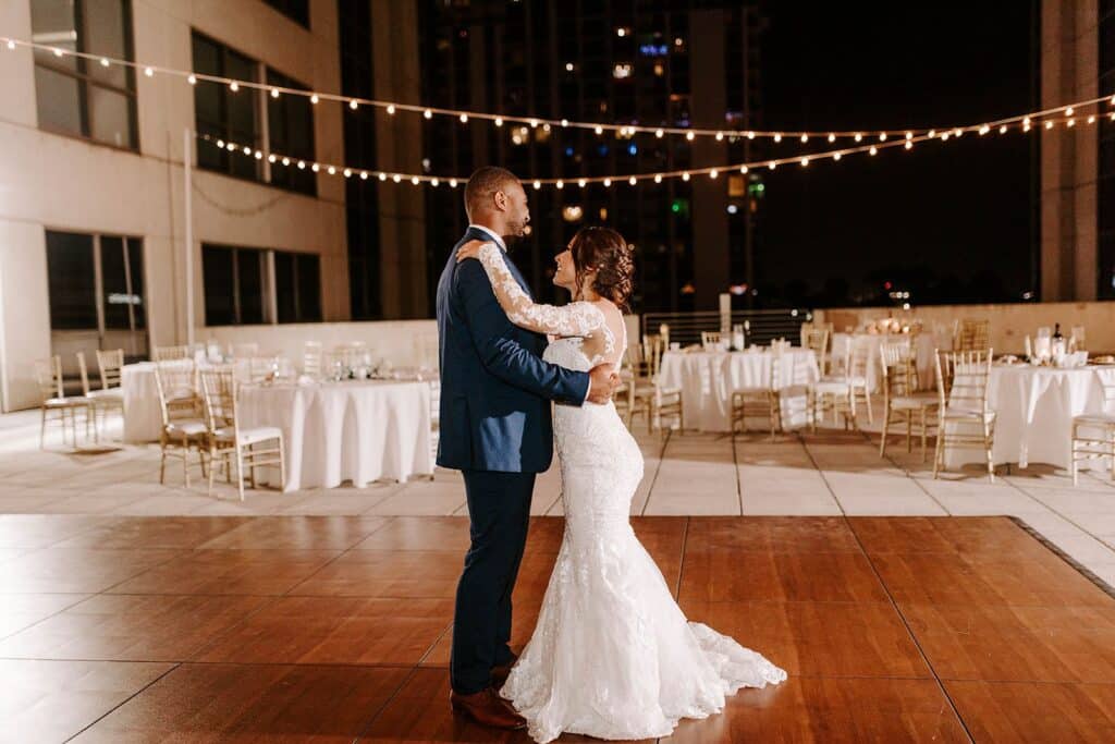 bride and groom dancing outdoors under the stars and market lights at The Balcony Orlando venue