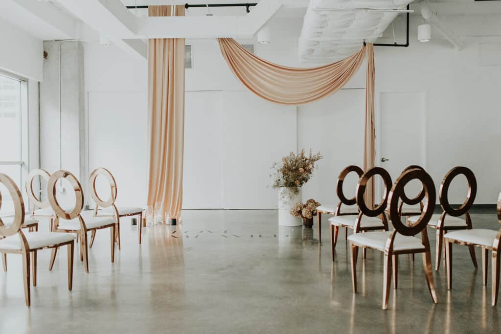 room draped in khaki and white linen, chairs in white and dark brown at The Balcony Orlando venue