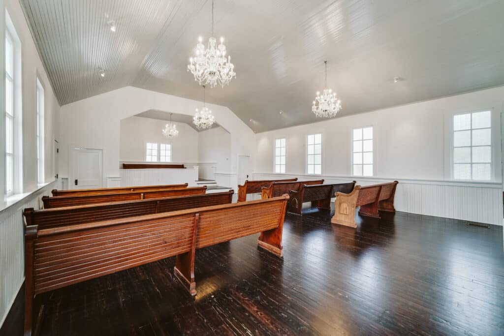 interior of a little chapel with wooden floors and crystal chandeliers at the Chapel & Cellar