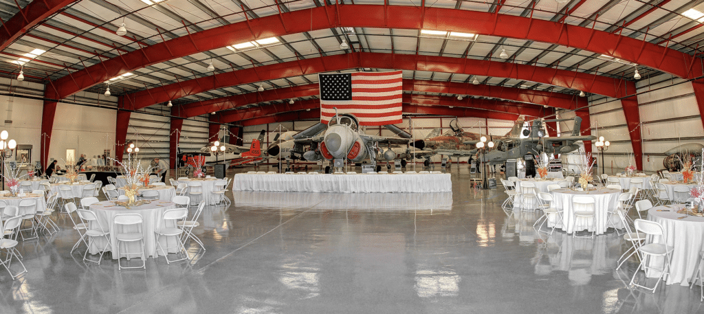 interior of an airplane hangar set up for a wedding reception at The Warbird Air Museum