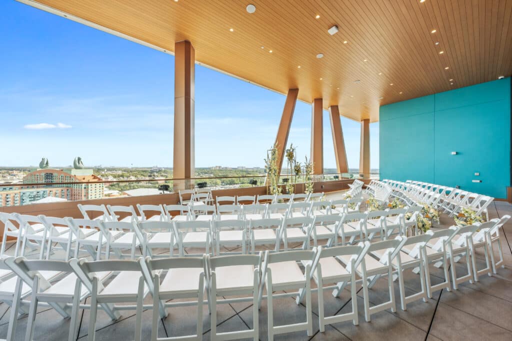 wedding reception in the round with white chairs set up in a semi circle looking out the window at Walt Disney World Swan Reserve