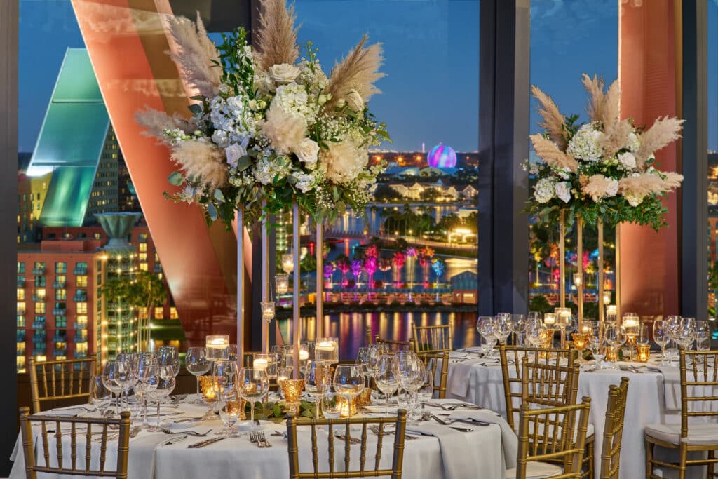 wedding reception set up with large round tables and tall centerpieces with Contemporary Hotel in the view at Walt Disney World Swan Reserve