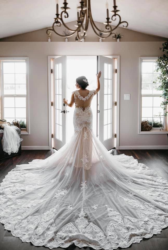bride silhouetted in bridal ready room with long train at October Oaks Farm