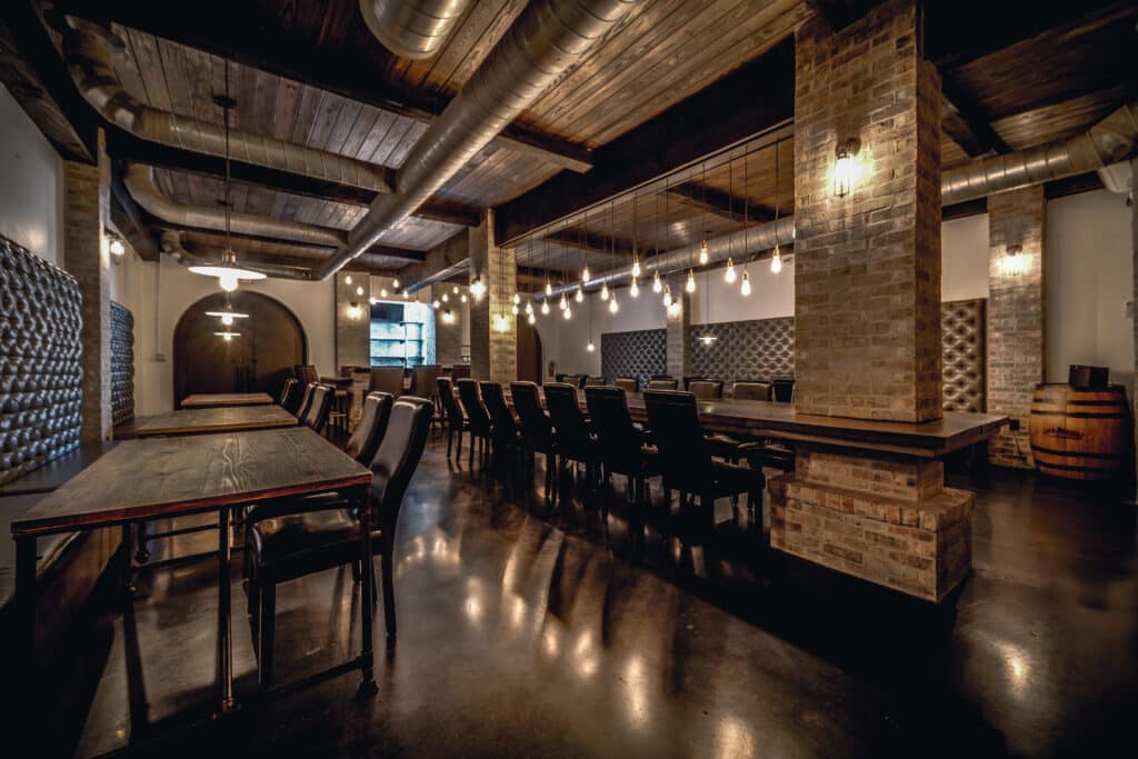 wooden bar with market lights and exposed pipes at the Chapel & Cellar