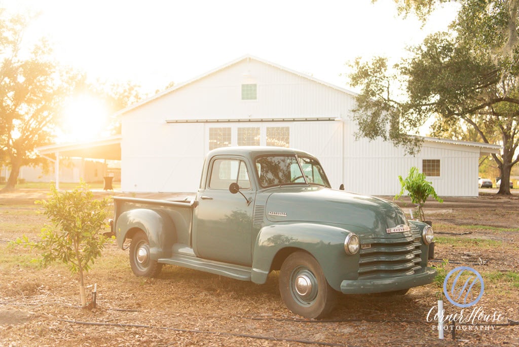 vintage truck sitting outside white barn at Ever After Farms Citrus Barn
