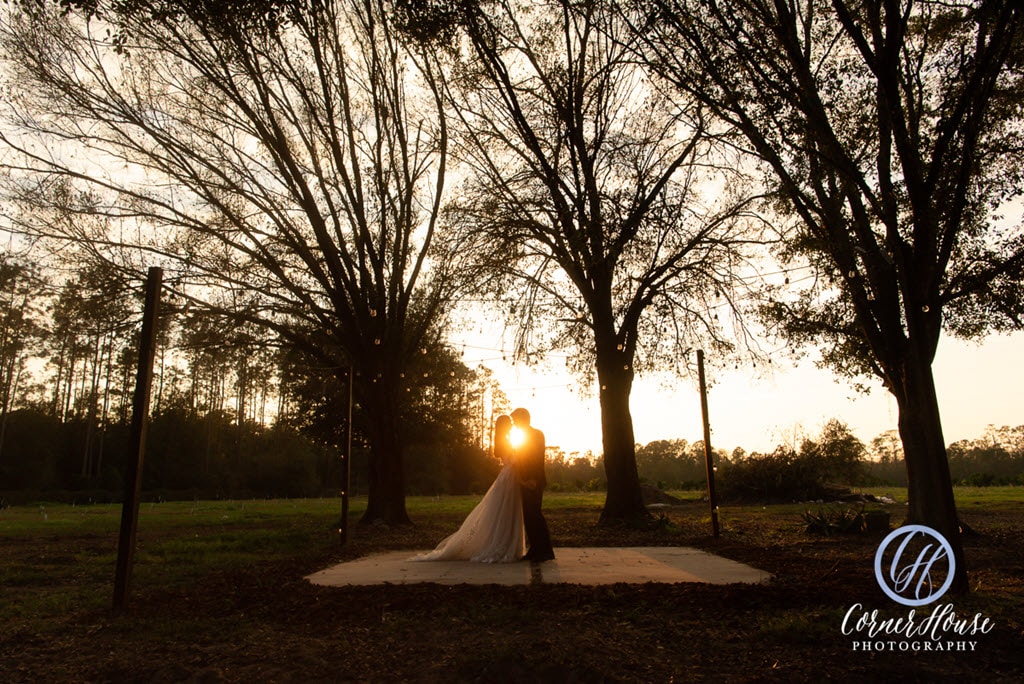 bride and groom silhouetted at sunset against the horizon at Ever After Farms Citrus Barn