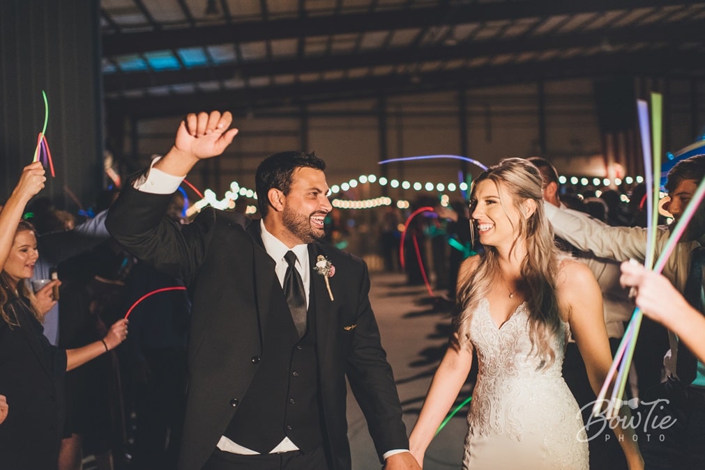 bride and groom smiling as they exit the airplane hangar at The Warbird Air Museum