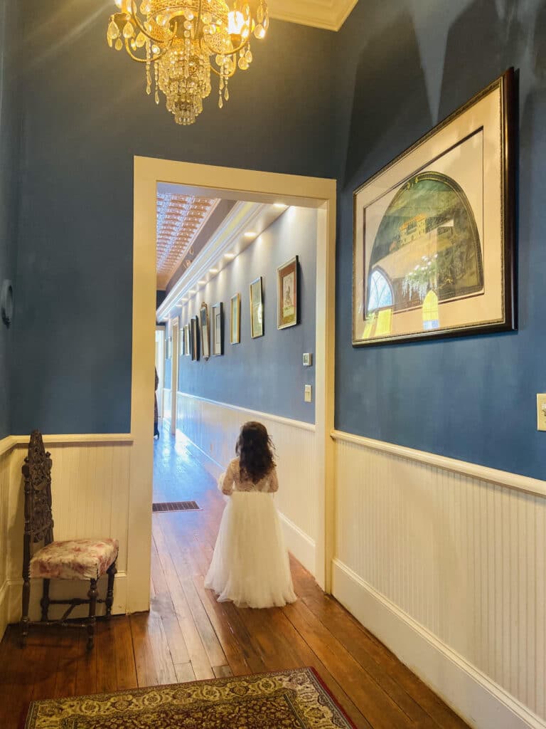 flower girl waking down hallway at THE 1883 Historic Venue