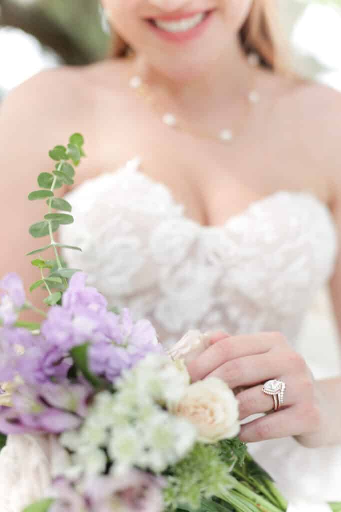 photo of bride with lavender and white bouquet and ruffled bodice of wedding gown by Sylvia Santos Photography