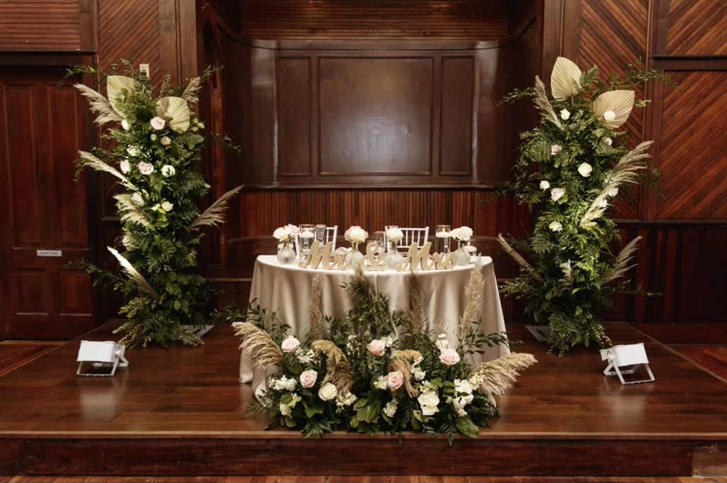 rich wooden room with sweethear table and lit planters at THE 1883 Historic Venue