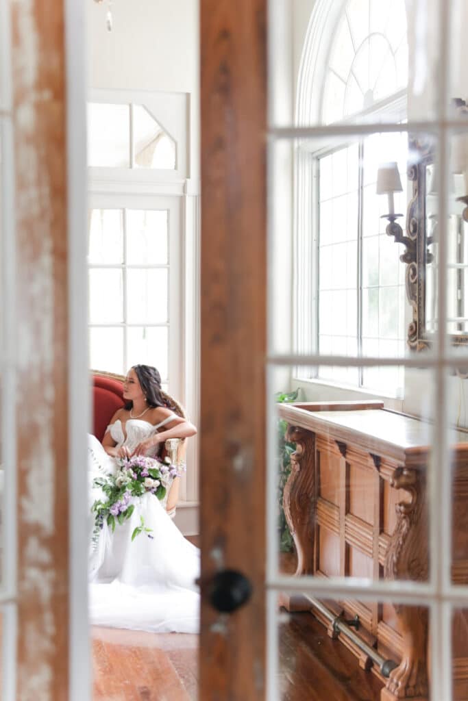 photo of bride through doors sitting and having a quiet moment before her wedding by Sylvia Santos Photography