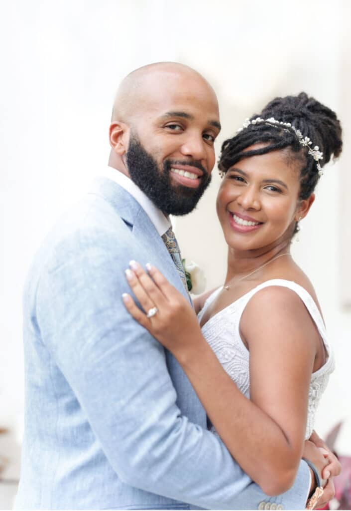 photo of bride with her hair in a bun and groom with a beard and in a light blue suit by Sylvia Santos Photography
