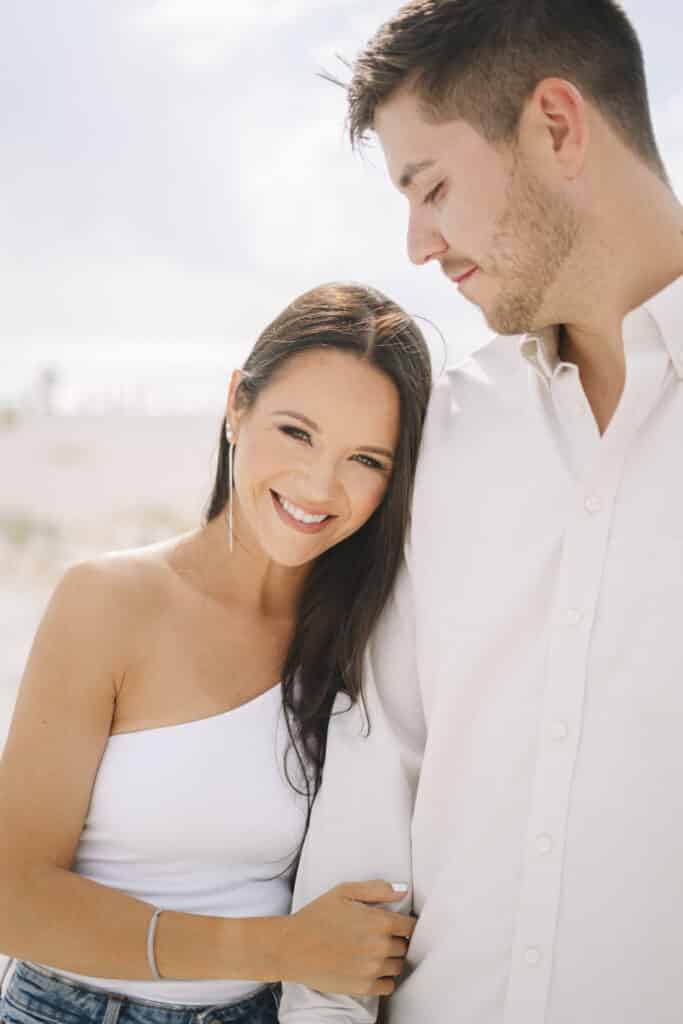 photo by Bouquet Photography of woman with white off the shoulder shirt smiling after she becomes engaged