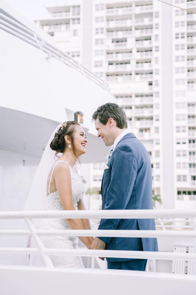 photo by Bouquet Photography of bride and groom sharing a laugh on the balcony of a high rise in a metropolitan area