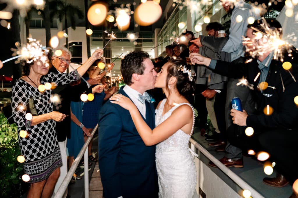 photo by Bouquet Photography of bride and groom leaving wedding under a walkway of sparklers