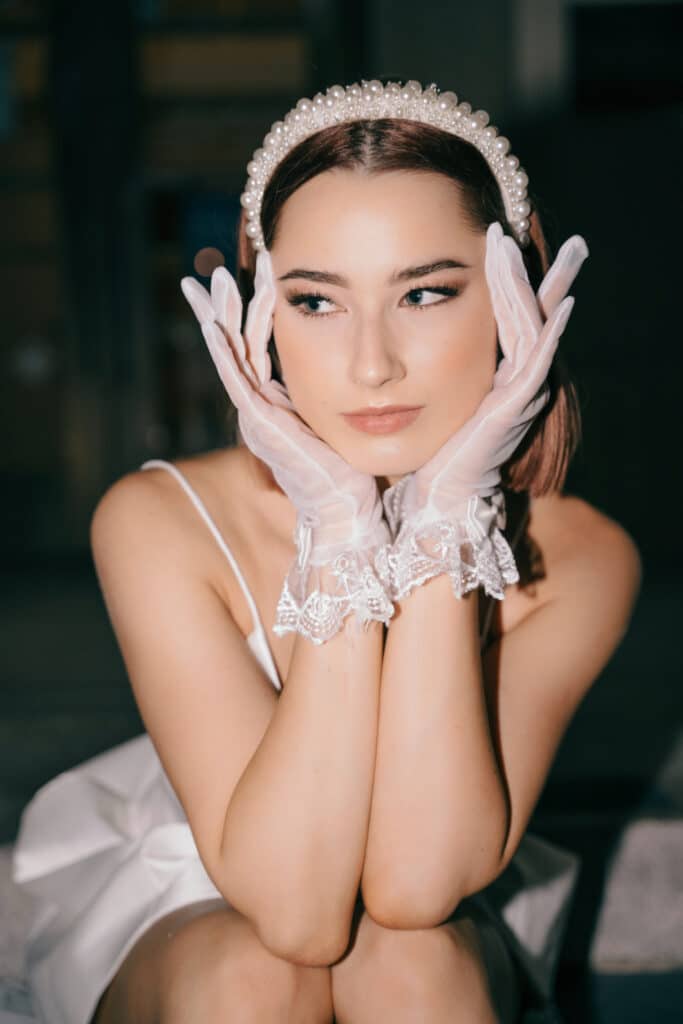 photo by Bouquet Photography of bride with pink gloves, tiara and silk spaghetti strap dress