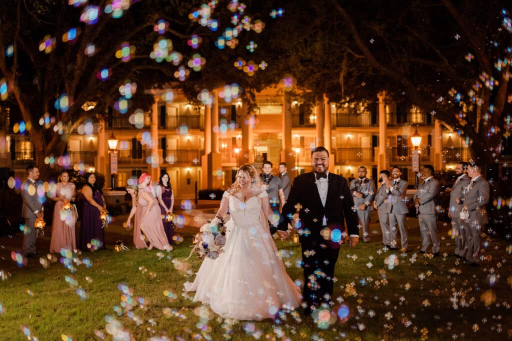 photo by Taylor Kuperberg Photography of bride and groom under a rainbow of bubbles