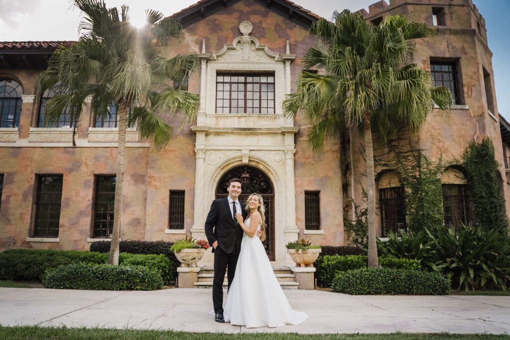 photo by Taylor Kuperberg Photography of bride and groom standing in front of Mediterranean stone building