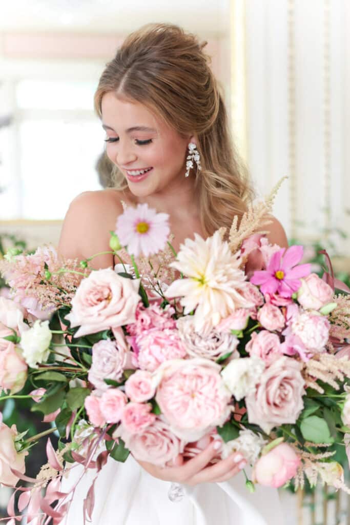 photo of bride holding large bouquet of different pink flowers by Sylvia Santos Photography