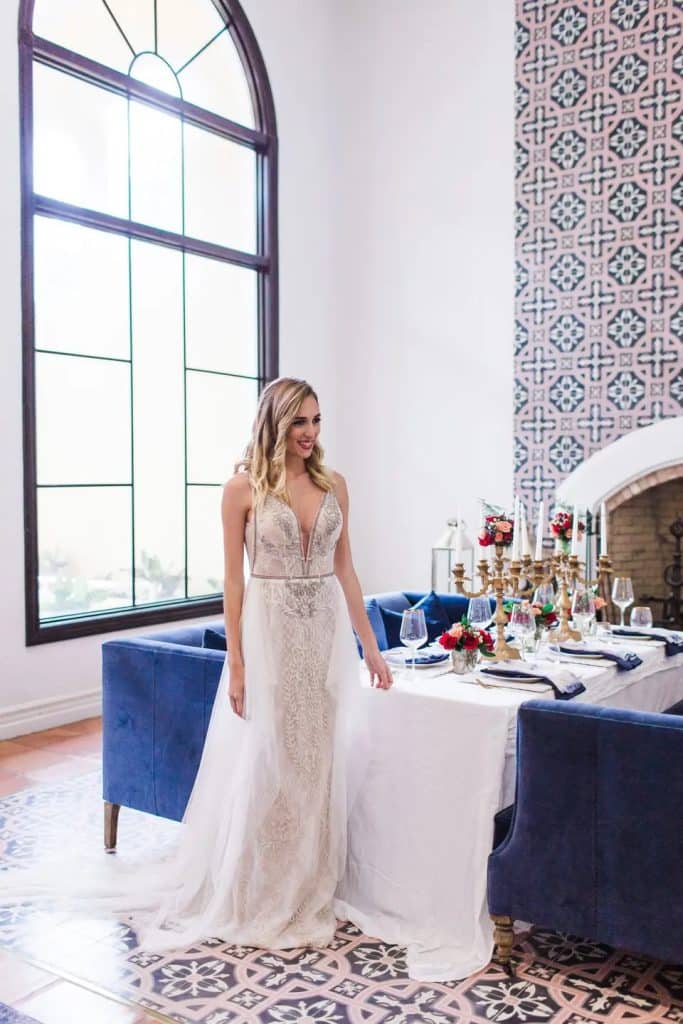 bride standing by reception table with blue seating and chairs at La Cita Country Club